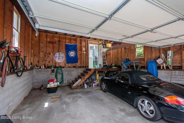 1211 Everett Ave, Louisville, KY 40204 - garage featuring wooden walls, a garage door opener, concrete block wall, and a workshop area