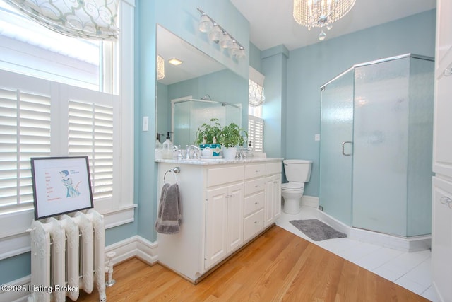 1211 Everett Ave, Louisville, KY 40204 - full bath featuring radiator heating unit, vanity, a stall shower, and wood finished floors