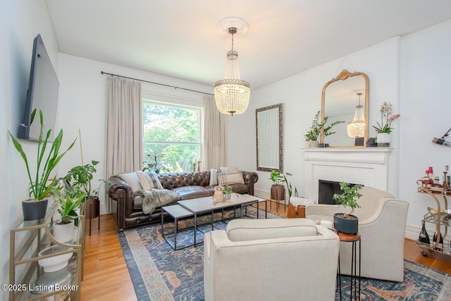 1211 Everett Ave, Louisville, KY 40204 - living area with wood finished floors, a chandelier, and a brick fireplace