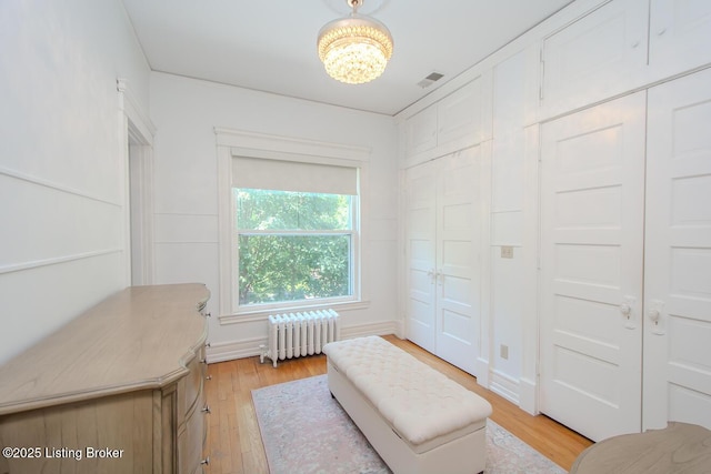 1211 Everett Ave, Louisville, KY 40204 - living area with radiator heating unit, a chandelier, and light wood-style floors