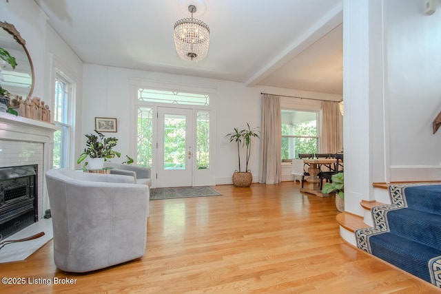 1211 Everett Ave, Louisville, KY 40204 - entryway featuring healthy amount of natural light, beamed ceiling, a chandelier, light wood-type flooring, and a glass covered fireplace