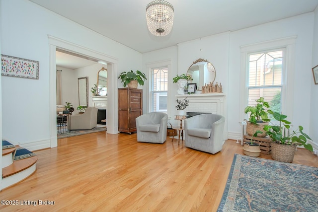1211 Everett Ave, Louisville, KY 40204 - living area featuring a brick fireplace, wood finished floors, and a chandelier