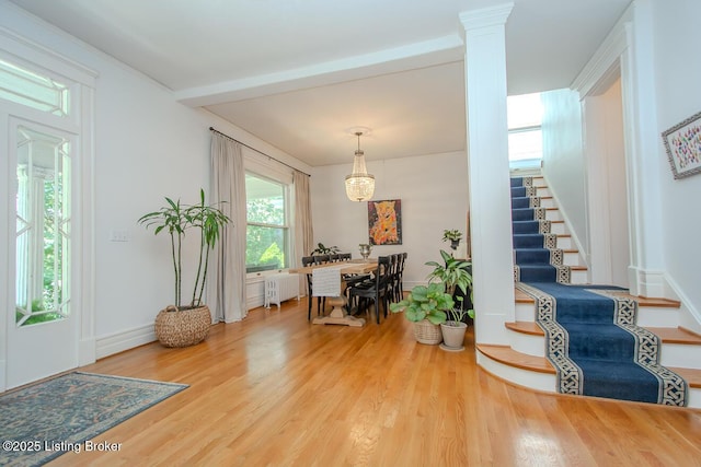 1211 Everett Ave, Louisville, KY 40204 - foyer entrance featuring radiator heating unit, stairway, wood finished floors, and ornate columns