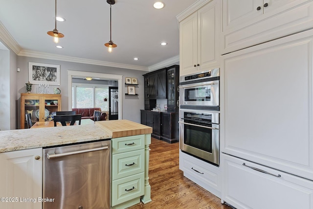 1700 Shady Ln, Louisville, KY 40205 - kitchen with stainless steel dishwasher, light wood-type flooring, white cabinetry, crown molding, and pendant lighting