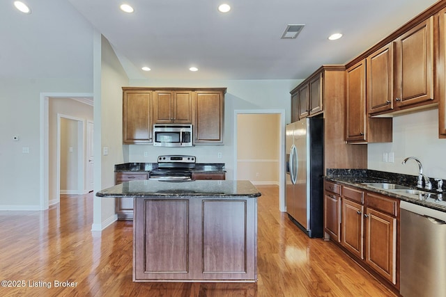 14518 Lake Village Dr Unit 4B, Louisville, KY 40299 - kitchen featuring stainless steel appliances, dark stone countertops, light wood-type flooring, a center island, and recessed lighting