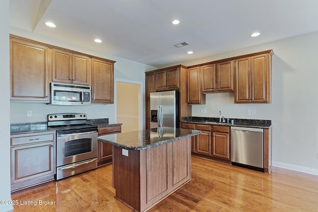 14518 Lake Village Dr Unit 4B, Louisville, KY 40299 - kitchen with stainless steel appliances, light wood-style floors, recessed lighting, a kitchen island, and dark stone countertops