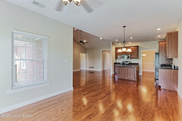 14518 Lake Village Dr Unit 4B, Louisville, KY 40299 - kitchen with appliances with stainless steel finishes, ceiling fan, dark countertops, open floor plan, and a center island