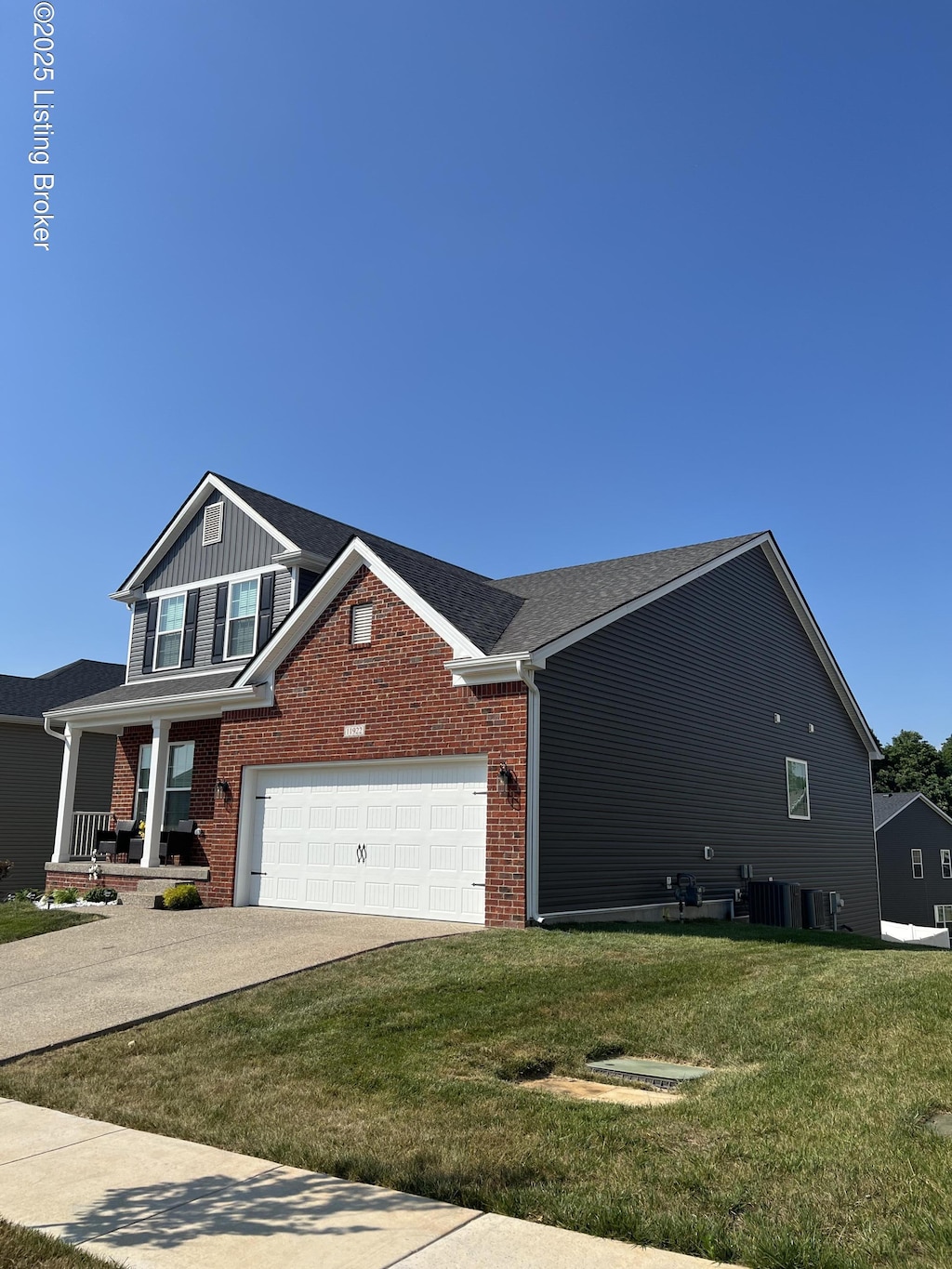 11922 Cascade Falls Trl, Louisville, KY 40229 - view of front facade featuring a garage, a front lawn, concrete driveway, and brick siding