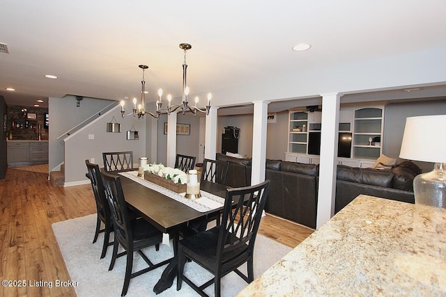 4201 Patterson Park Ct, Louisville, KY 40299 - dining area featuring light wood-style floors, ornate columns, a chandelier, stairs, and recessed lighting