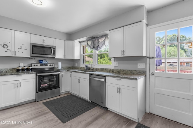 6206 Tabor Dr, Louisville, KY 40218 - kitchen featuring stainless steel appliances, white cabinetry, and dark stone counters