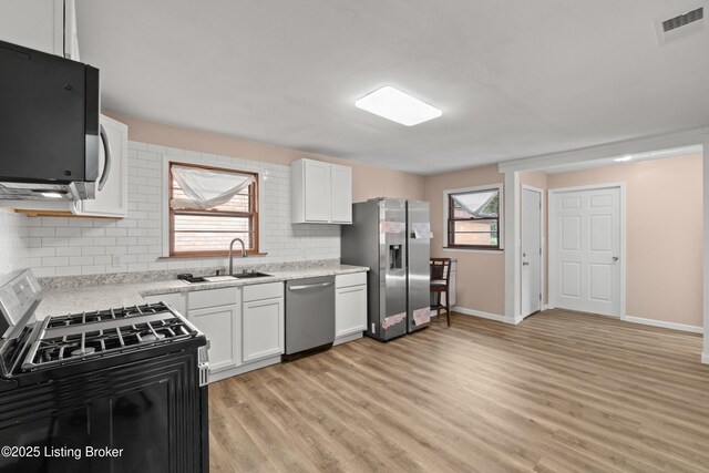 3322 Virginia Ave, Louisville, KY 40211 - kitchen featuring stainless steel appliances, light wood-style floors, plenty of natural light, and light countertops