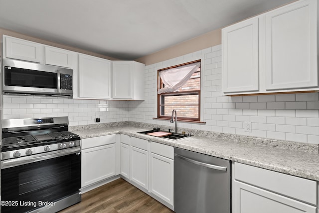 3322 Virginia Ave, Louisville, KY 40211 - kitchen with stainless steel appliances, white cabinetry, wood finished floors, and decorative backsplash