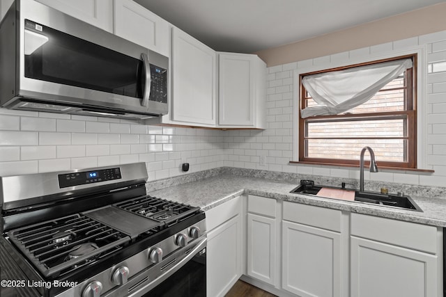 3322 Virginia Ave, Louisville, KY 40211 - kitchen with stainless steel appliances, white cabinets, light countertops, and tasteful backsplash