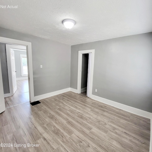 1412 Beech St, Louisville, KY 40211 - empty room with a textured ceiling and light wood-type flooring