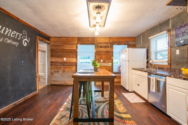 650 Midway Rd, Guston, KY 40142 - kitchen featuring stainless steel dishwasher, freestanding refrigerator, dark countertops, healthy amount of natural light, and wooden walls