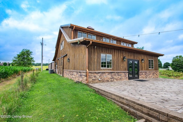 650 Midway Rd, Guston, KY 40142 - view of front of house featuring french doors, a front lawn, board and batten siding, and stone siding