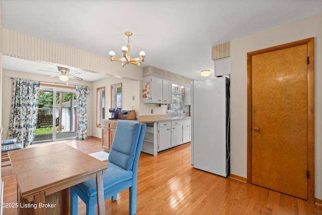 8703 Fernview Dr, Louisville, KY 40291 - kitchen with freestanding refrigerator, a chandelier, light wood-style flooring, and light countertops