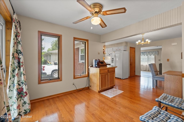 8703 Fernview Dr, Louisville, KY 40291 - kitchen with white refrigerator with ice dispenser, a chandelier, healthy amount of natural light, and light wood-type flooring