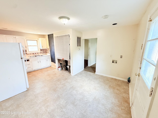 5123 Reed Ave, Louisville, KY 40214 - kitchen featuring freestanding refrigerator, light countertops, tasteful backsplash, and white cabinetry