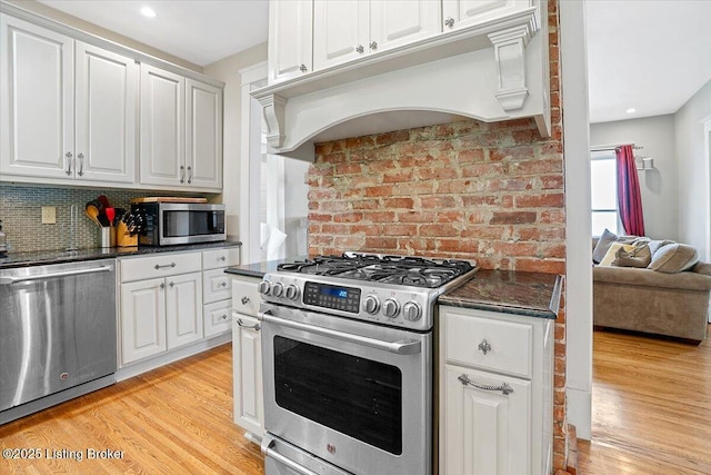 2449 Ransdell Ave, Louisville, KY 40204 - kitchen with appliances with stainless steel finishes, under cabinet range hood, light wood-style floors, white cabinets, and recessed lighting