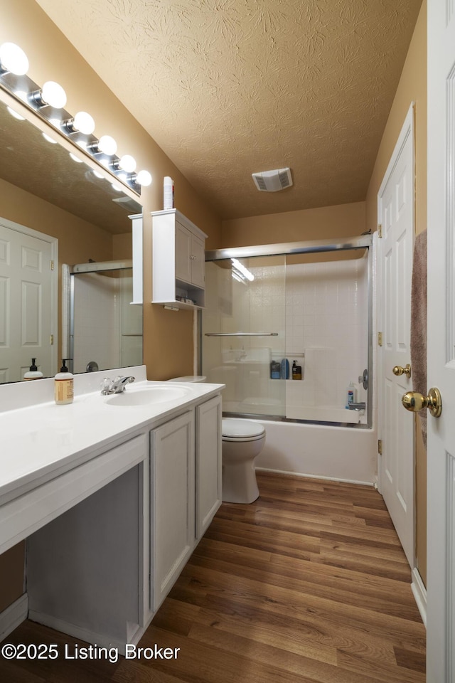 6716 Arbor Creek Dr, Louisville, KY 40228 - bathroom featuring a textured ceiling, wood finished floors, vanity, and combined bath / shower with glass door