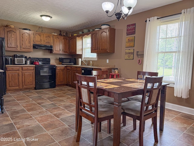 1410 Sycamore Ln, Leitchfield, KY 42754 - kitchen featuring black appliances, under cabinet range hood, a chandelier, brown cabinetry, and a textured ceiling