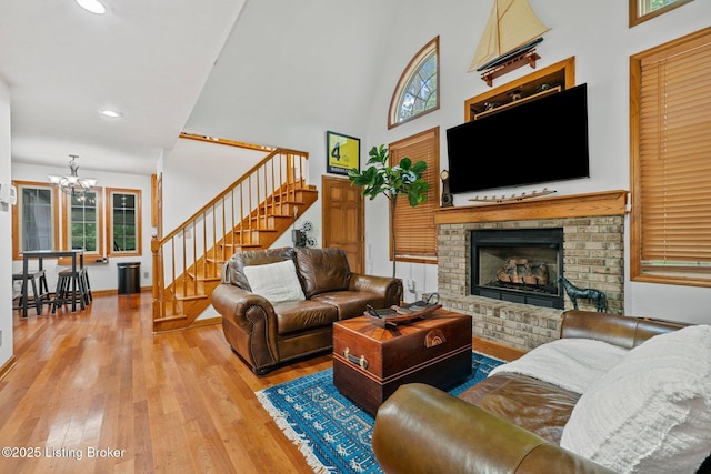171 Cedar Point Rd, Bee Spring, KY 42207 - living area with stairway, a chandelier, hardwood / wood-style floors, a fireplace, and a high ceiling