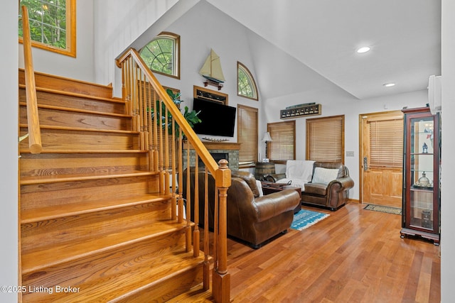 171 Cedar Point Rd, Bee Spring, KY 42207 - staircase featuring wood finished floors, a high ceiling, a fireplace, and recessed lighting