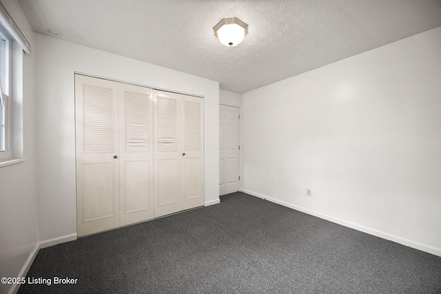 547 Wyandot Ct, Radcliff, KY 40160 - unfurnished bedroom featuring dark carpet, a textured ceiling, a closet, and multiple windows
