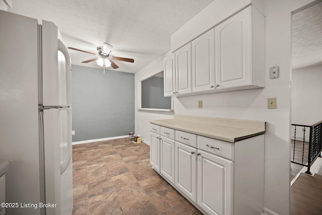547 Wyandot Ct, Radcliff, KY 40160 - kitchen with freestanding refrigerator, ceiling fan, a textured ceiling, white cabinetry, and light countertops