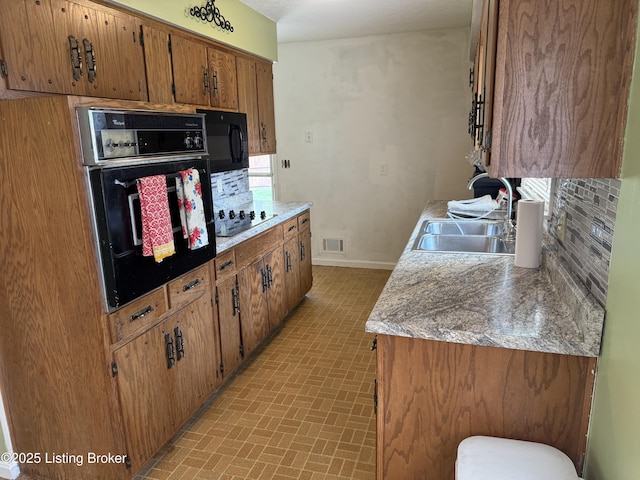 1001 Caney Fork Rd, Bardstown, KY 40004 - kitchen with black appliances, brown cabinetry, decorative backsplash, and light countertops