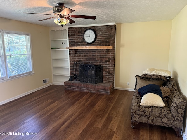 1001 Caney Fork Rd, Bardstown, KY 40004 - living area featuring a textured ceiling, wood finished floors, ceiling fan, built in shelves, and a brick fireplace