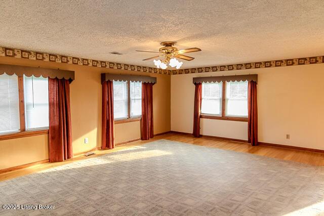 4883 S Reeves Rd, Scottsburg, IN 47170 - spare room featuring wood finished floors, ceiling fan, and a textured ceiling