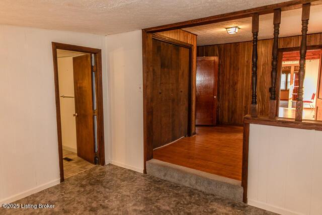 4883 S Reeves Rd, Scottsburg, IN 47170 - hallway featuring carpet, a textured ceiling, and wooden walls