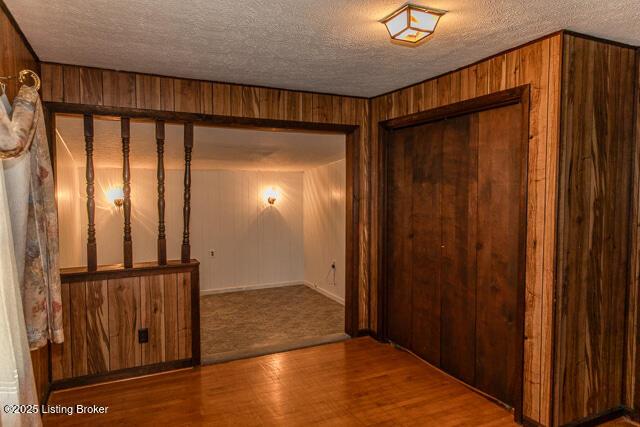 4883 S Reeves Rd, Scottsburg, IN 47170 - spare room featuring wood finished floors, wood walls, and a textured ceiling