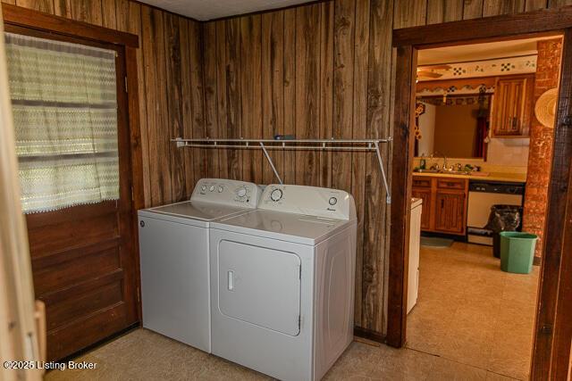 4883 S Reeves Rd, Scottsburg, IN 47170 - washroom featuring washing machine and dryer, wood walls, and light floors