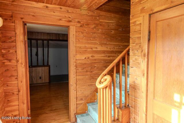 4883 S Reeves Rd, Scottsburg, IN 47170 - stairway featuring wood walls, wooden ceiling, and wood finished floors