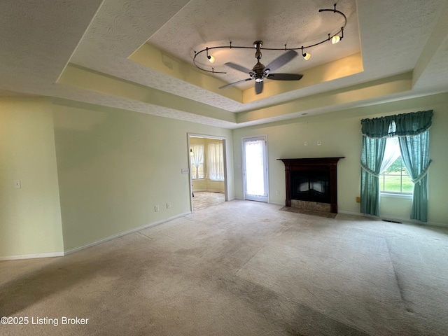 8 San Juan Ct, Elizabethtown, KY 42701 - unfurnished living room with a tray ceiling, carpet, ceiling fan, a fireplace with flush hearth, and a textured ceiling