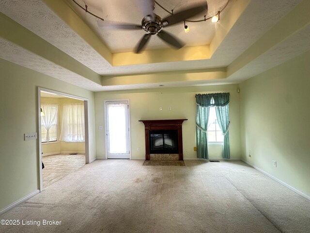 8 San Juan Ct, Elizabethtown, KY 42701 - unfurnished living room with a tray ceiling, carpet flooring, a ceiling fan, and a fireplace with flush hearth