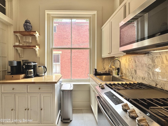 416 Belgravia Ct, Louisville, KY 40208 - kitchen featuring appliances with stainless steel finishes, backsplash, white cabinetry, and light tile patterned flooring