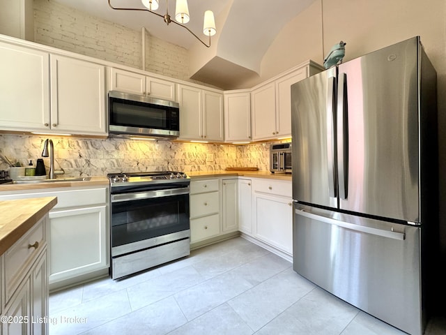 416 Belgravia Ct, Louisville, KY 40208 - kitchen with stainless steel appliances, tasteful backsplash, white cabinetry, light tile patterned floors, and a chandelier