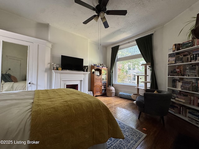 416 Belgravia Ct, Louisville, KY 40208 - bedroom featuring a textured ceiling, wood finished floors, a fireplace, and a ceiling fan