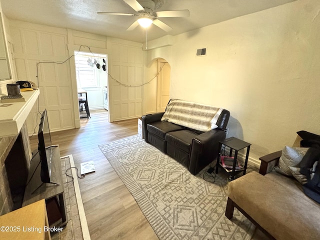 416 Belgravia Ct, Louisville, KY 40208 - living area featuring wood finished floors, a ceiling fan, and arched walkways