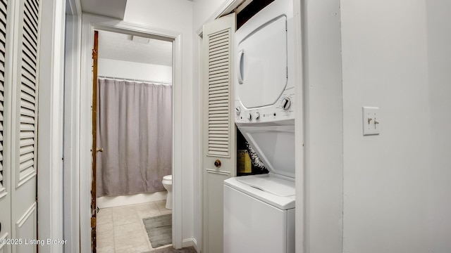 213 Fairfax Ave Apt 4, Louisville, KY 40207 - washroom with stacked washer / dryer and tile patterned floors