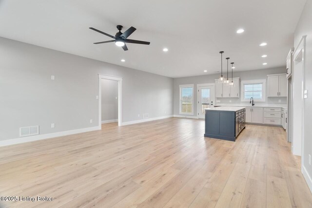 488 Capps Rd, Campbellsville, KY 42718 - kitchen with open floor plan, light countertops, light wood-type flooring, a kitchen island, and ceiling fan