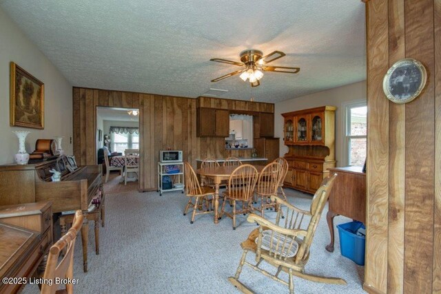 825 Crocus Dr, Radcliff, KY 40160 - carpeted dining space featuring a ceiling fan, a textured ceiling, plenty of natural light, and wood walls
