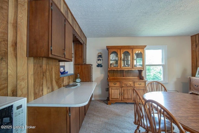 825 Crocus Dr, Radcliff, KY 40160 - kitchen featuring a textured ceiling, brown cabinets, light carpet, light countertops, and a peninsula
