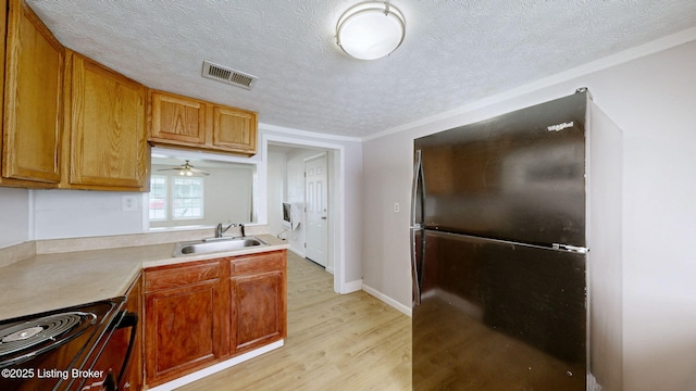 1117 6th St, Carrollton, KY 41008 - kitchen featuring freestanding refrigerator, a textured ceiling, light wood-type flooring, range with electric stovetop, and light countertops