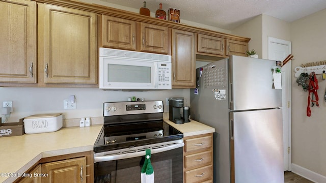 7236 Michael Benjamin Cir, Crestwood, KY 40014 - kitchen featuring white microwave, stainless steel electric stove, freestanding refrigerator, and light countertops