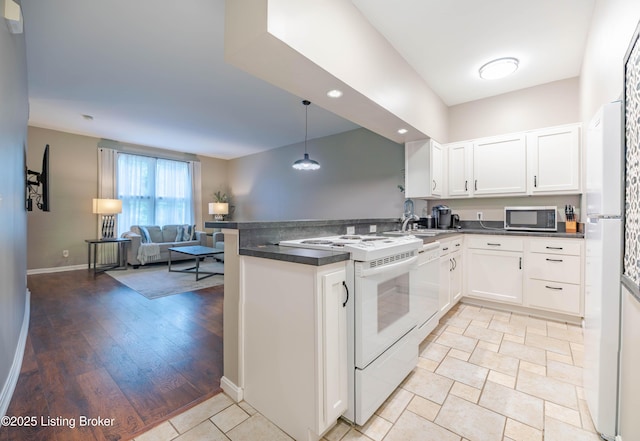 2745 Grinstead Dr Apt 113, Louisville, KY 40206 - kitchen featuring a peninsula, white appliances, dark countertops, open floor plan, and recessed lighting